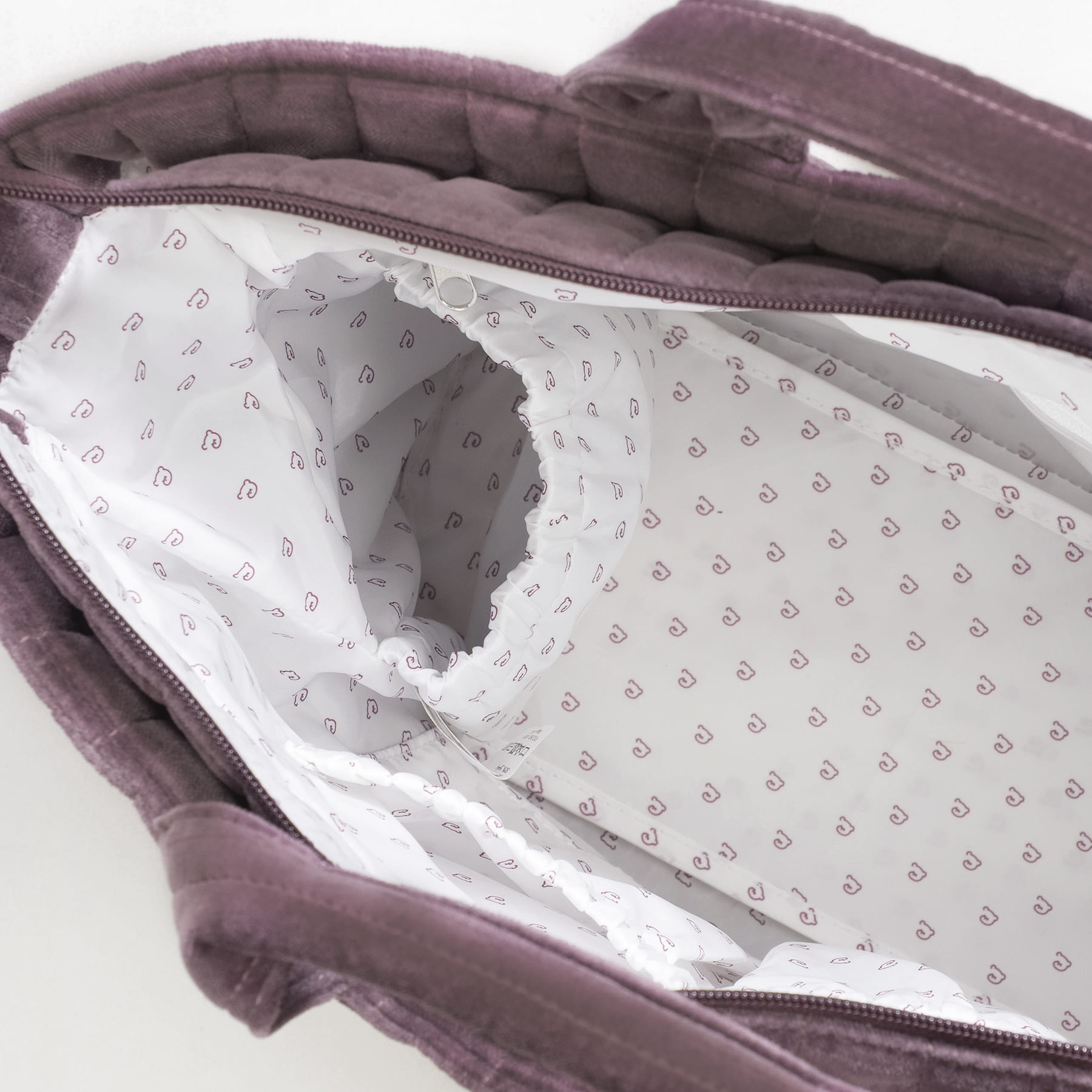 Interior de bolsa roxa com forro branco e padrão de ícones