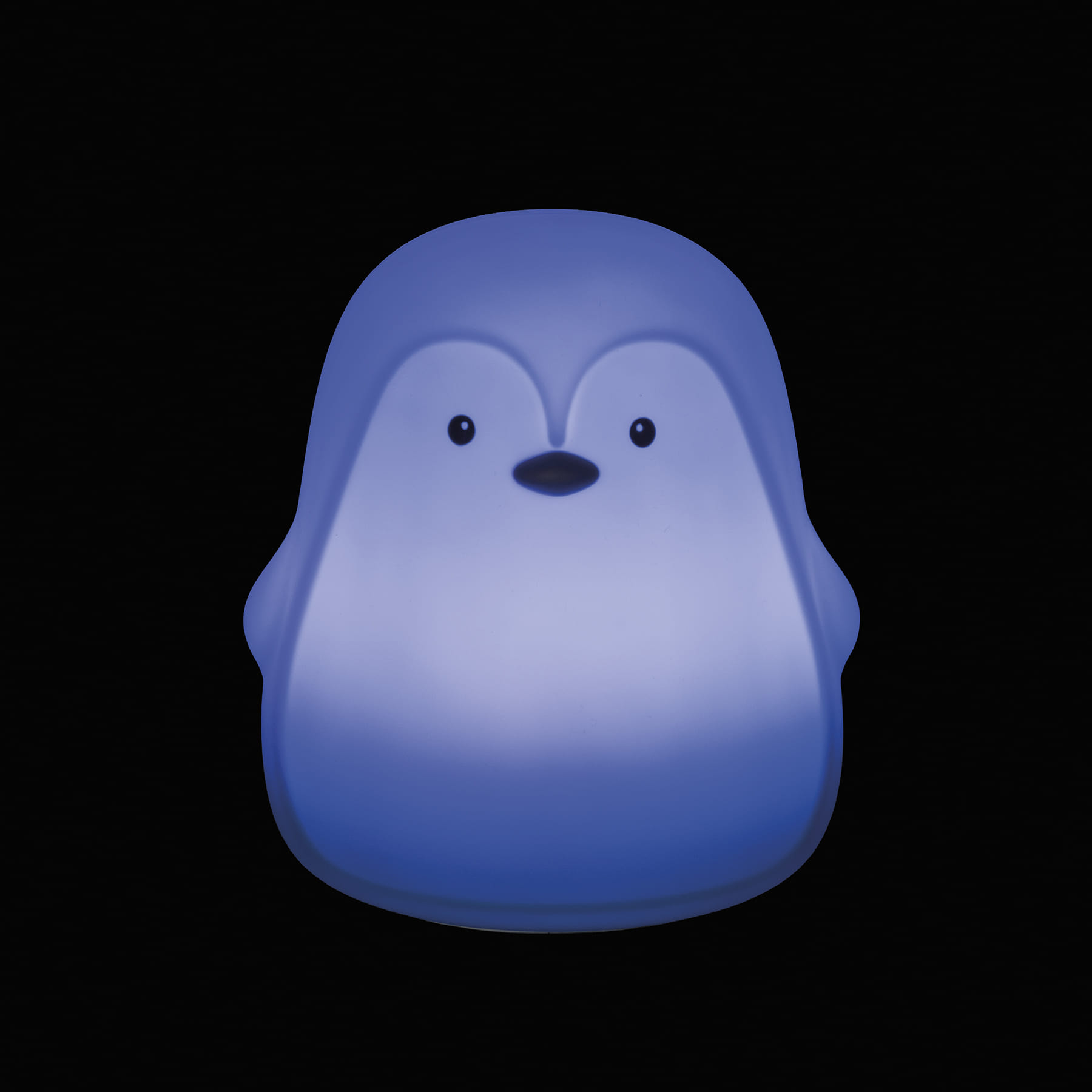 Luminária de pinguim azul iluminada sobre fundo preto