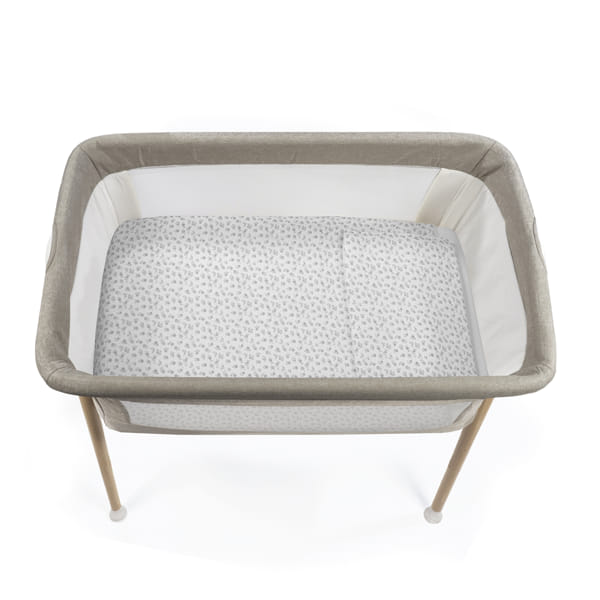 Berço de bebé cinzento com padrão de folhas e estrutura em madeira clara