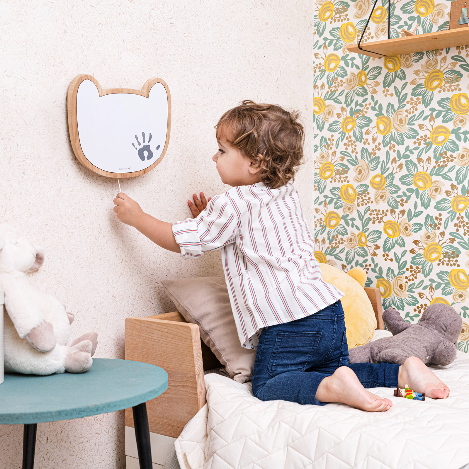 Relógio de parede infantil em forma de rosto de urso com criança ajoelhada na cama ao lado