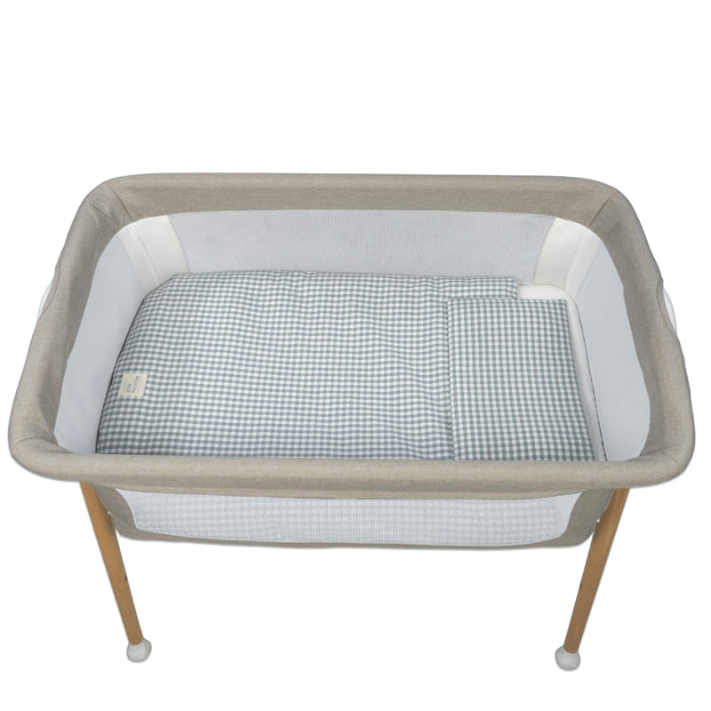 Berço portátil para bebés com estrutura de madeira clara e tecido bege e branco