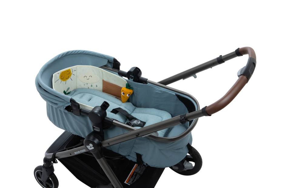 Carrinho de bebé azul claro com decoração acolchoada colorida e pega castanha