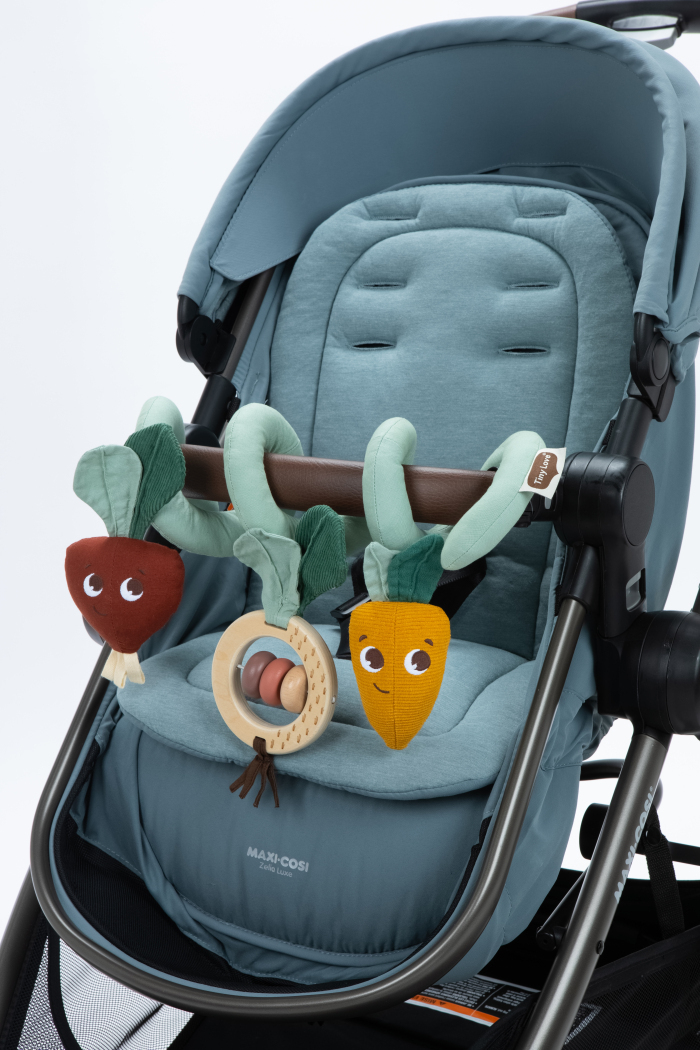 Carrinho de bebé azul com brinquedos em tecido a pendurar na barra frontal