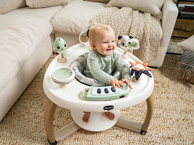 Andarilho branco com pernas de madeira e bebé a brincar sentado