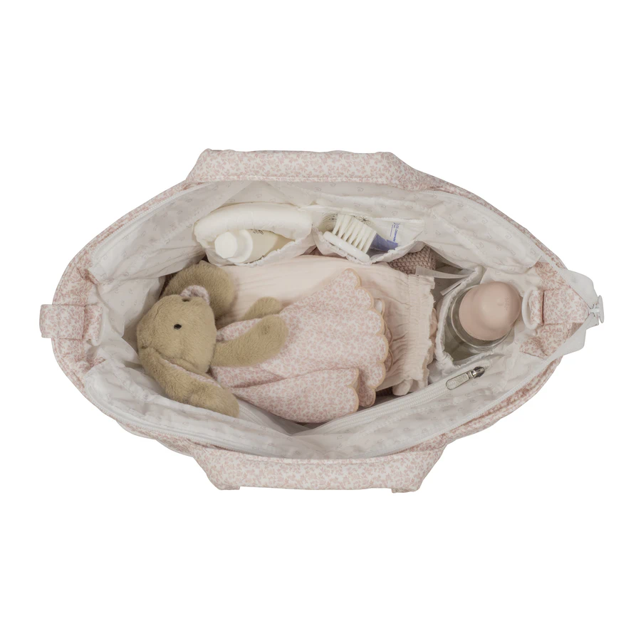 Mala de bebé aberta com brinquedo de peluche, biberão, escova e roupa cor de rosa
