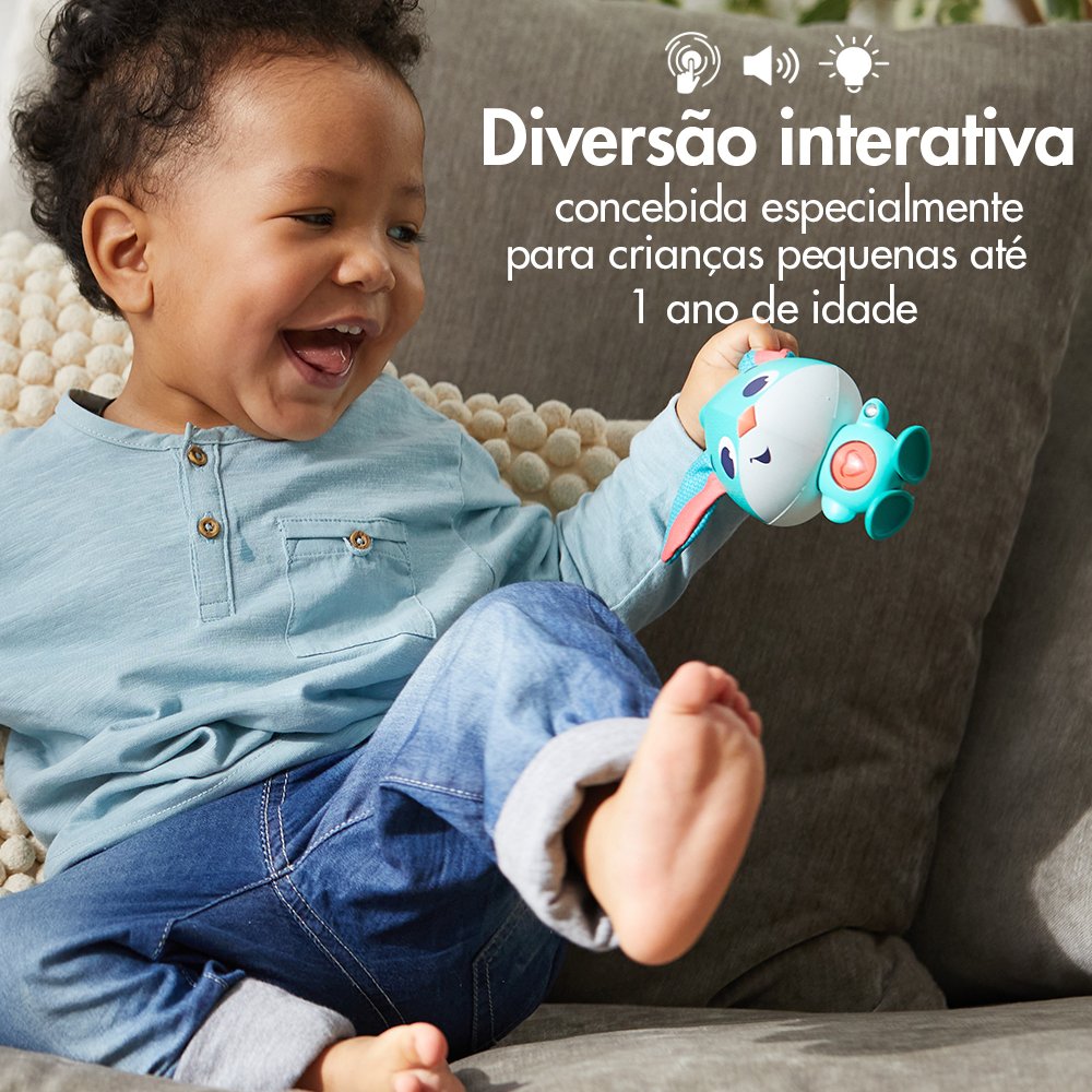 Criança com brinquedo interativo sentado em sofá cinzento