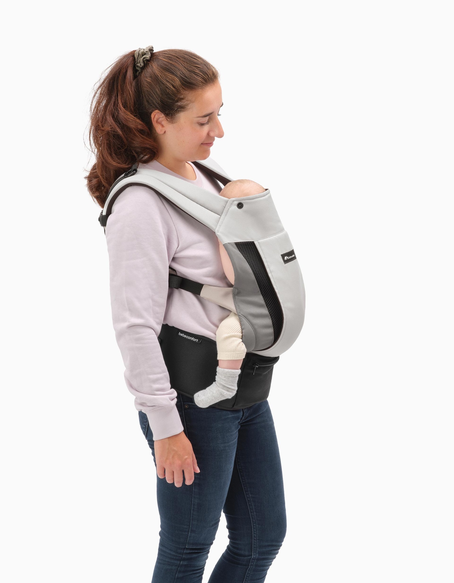 Portadora de bebé cinzenta e preta com suporte lombar usada por mulher com bebé