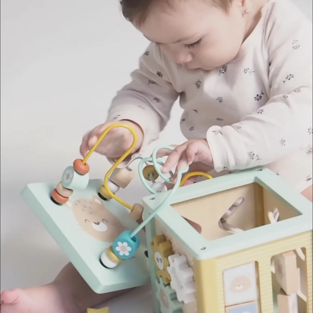 Bebé a brincar com cubo educativo de madeira com contas coloridas e peças móveis