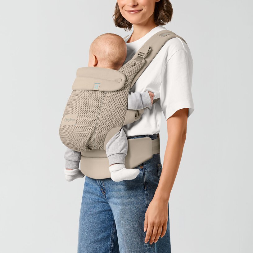 Mochila porta-bebés cinzenta bege com bebé e mulher com roupa casual