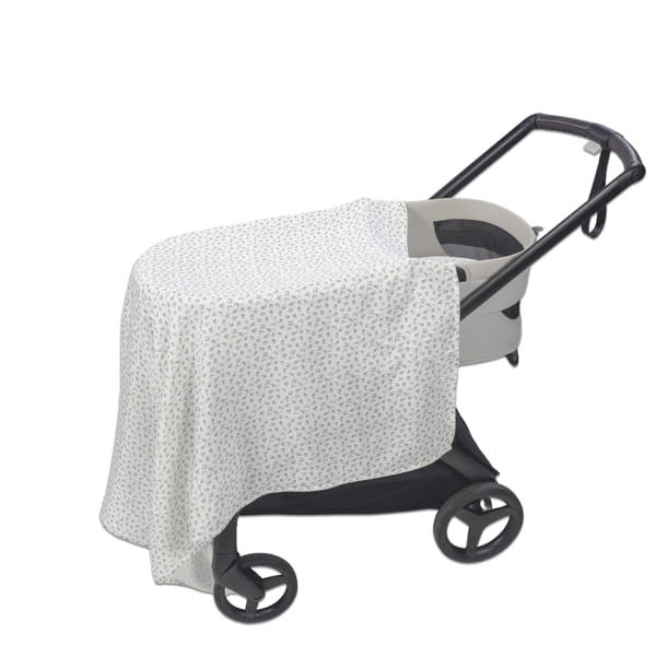 Carrinho de bebé cinzento com capa branca com padrão
