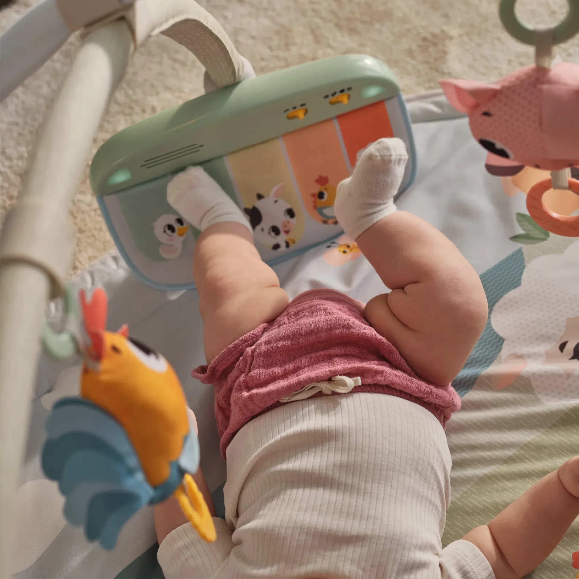 Tapete de atividade infantil com brinquedos suspensos e bebé deitado de costas
