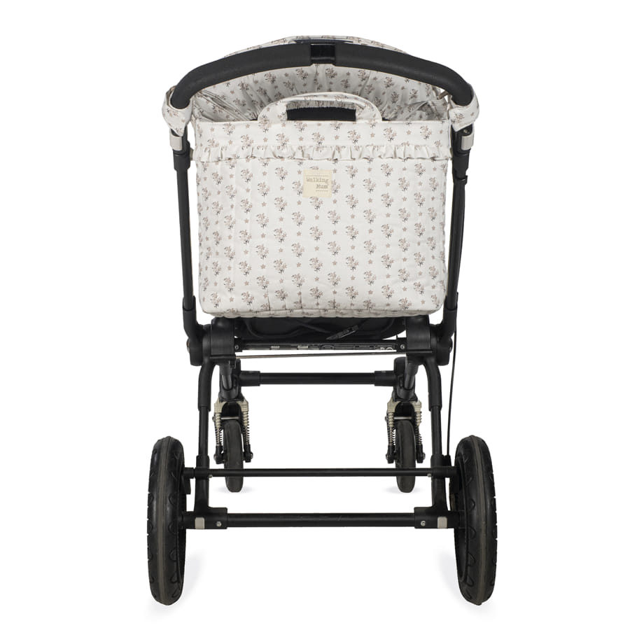 Carrinho de bebé com tecido floral branco visto de trás