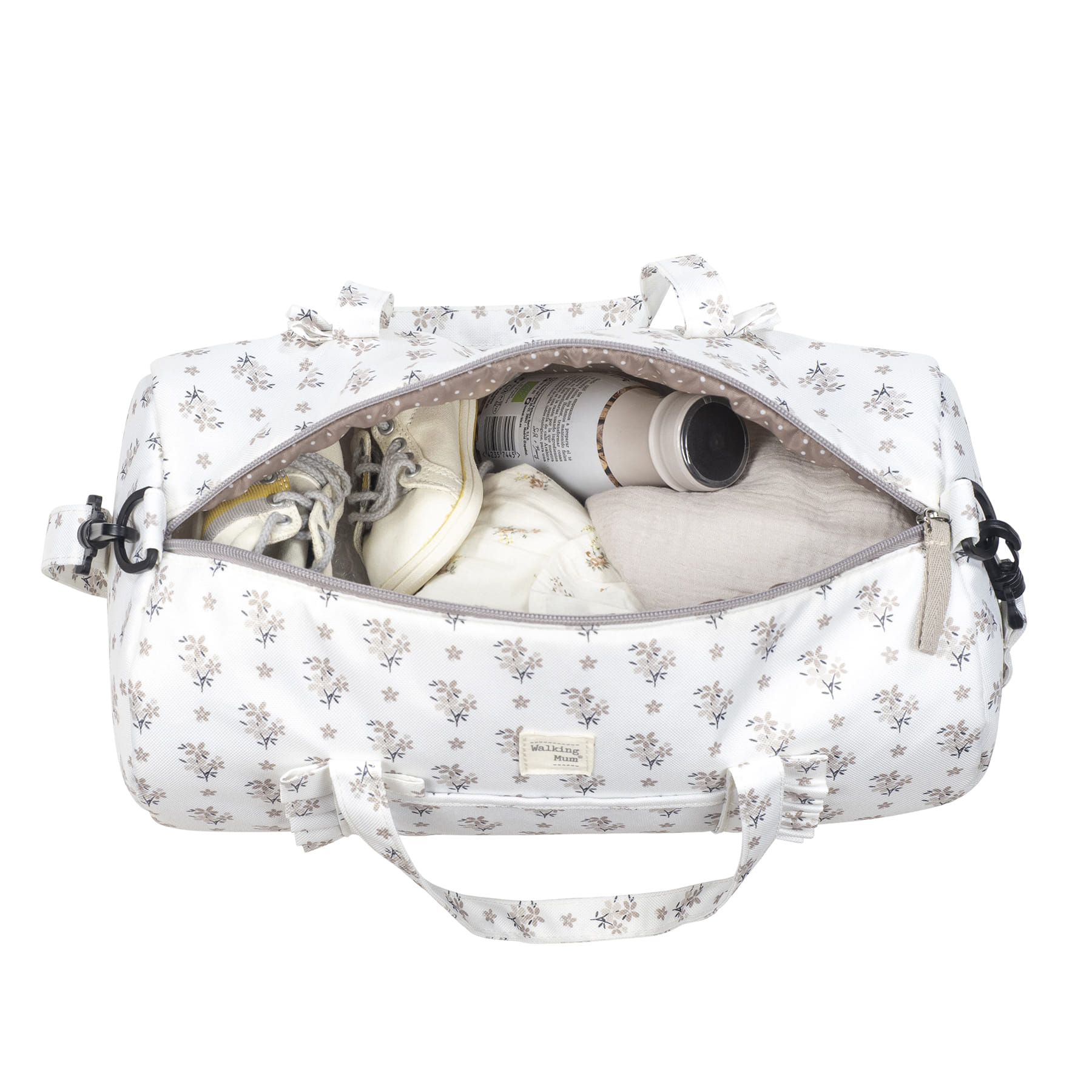 Mala de maternidade branca e floral aberta com itens de bebé