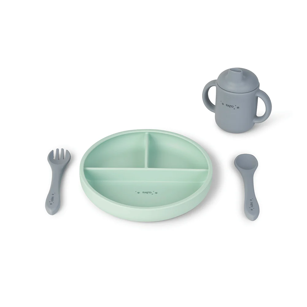 Conjunto de alimentação infantil em silicone com prato verde claro dividido em três compartimentos, colher, garfo e copo cinzento