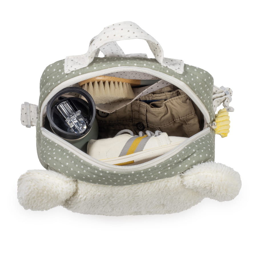 Bolsa aberta verde com bolinhas brancas e alças, mostrando itens de bebé dentro