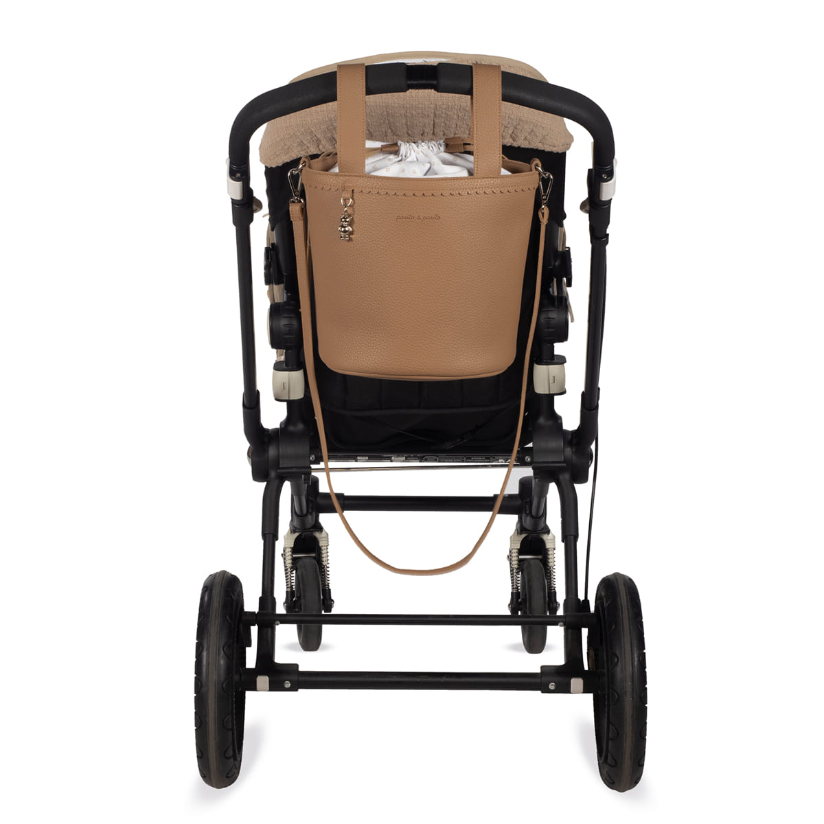 Carrinho de bebé preto com bolsa castanha pendurada na parte traseira