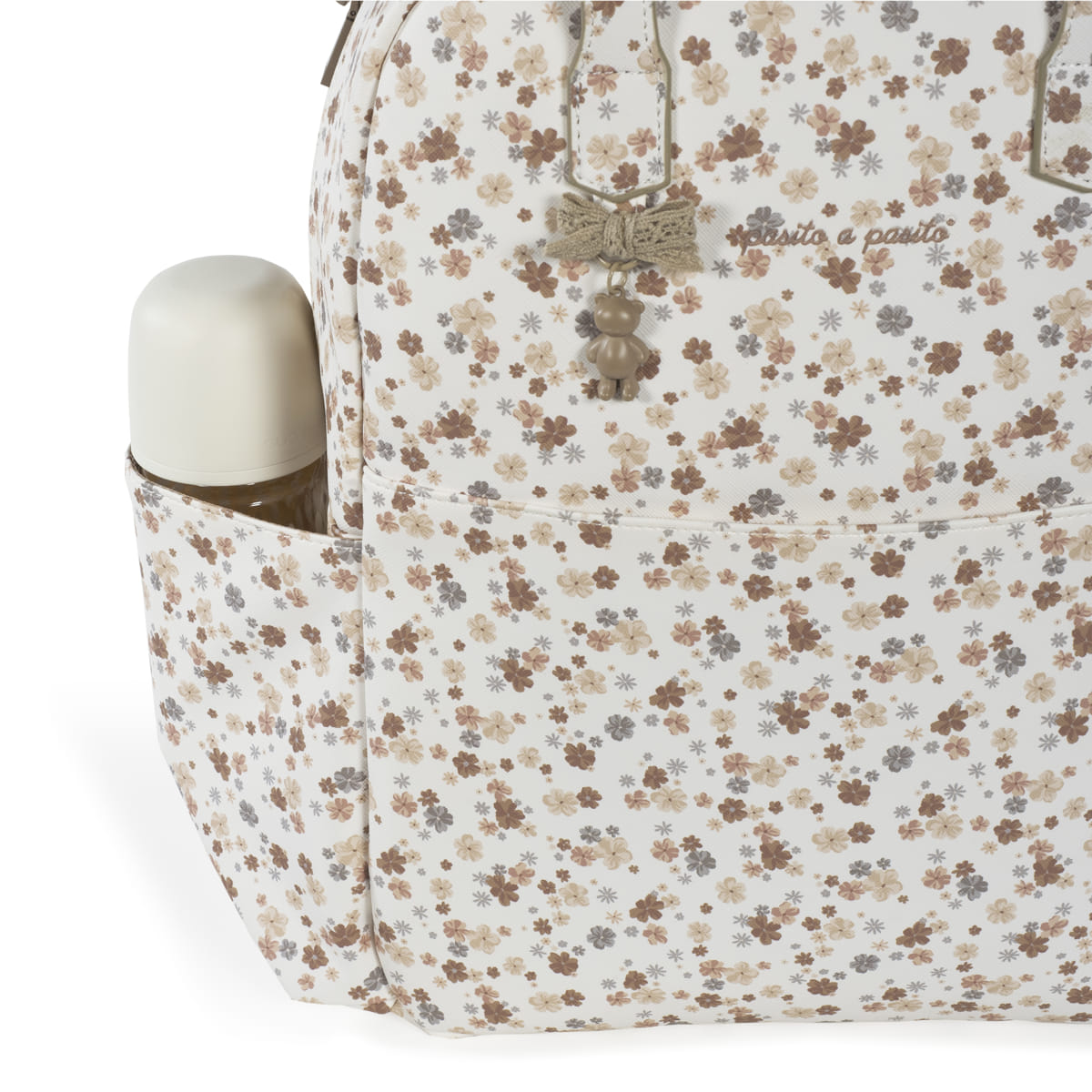 mochila floral bege e castanha com biberão branco no bolso lateral