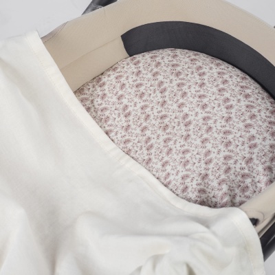 Interior de carrinho com almofada floral lilás e manta branca