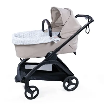 Carrinho de bebê bege com interior floral e estrutura preta