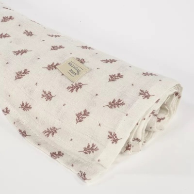 Pano branco com padrão de ramos castanhos e etiqueta visível