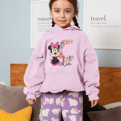 Menina vestindo hoodie lilás com estampa da Minnie e calças com ursos em sala