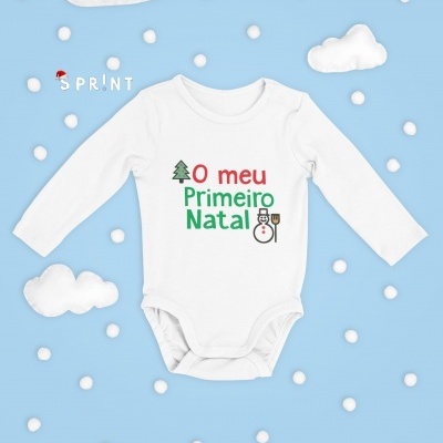 Body branco de manga comprida para bebé com texto 'O meu Primeiro Natal' e desenhos natalícios, sobre fundo azul com nuvens e bolas brancas.