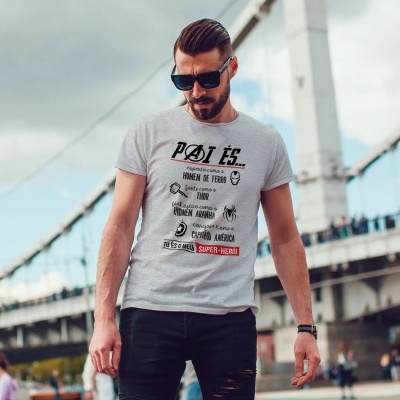 Homem com t-shirt cinzenta e óculos escuros junto a ponte branca