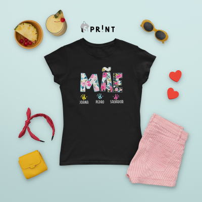 T-shirt preta com estampa floral e nomes, rodeada por acessórios e calças rosa sobre fundo azul claro