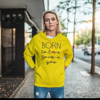 Mulher com sweatshirt amarela 'BORN to love you' em ambiente urbano