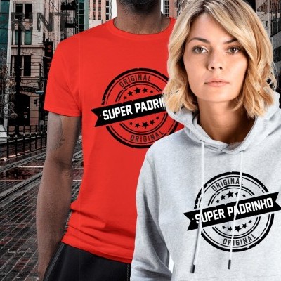 Homem com t-shirt vermelha e mulher com hoodie cinza claro, ambos com estampa 'SUPER PADRINHO ORIGINAL', em ambiente urbano.