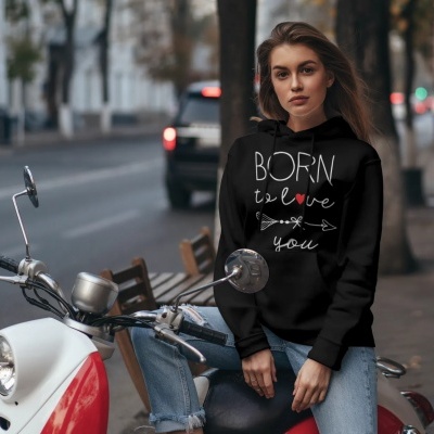 Mulher jovem sentada numa mota, usando sweatshirt preta com texto 'BORN to love you'