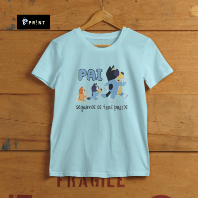 Camiseta azul clara com estampa de cães e texto 'PAI seguimos os teus passos'