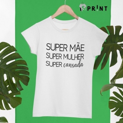 T-shirt branca com texto preto pendurada em cabide num fundo verde com folhas de planta.