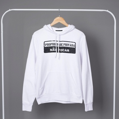 Sweatshirt branca com texto preto suspensa num cabide em estrutura metálica branca