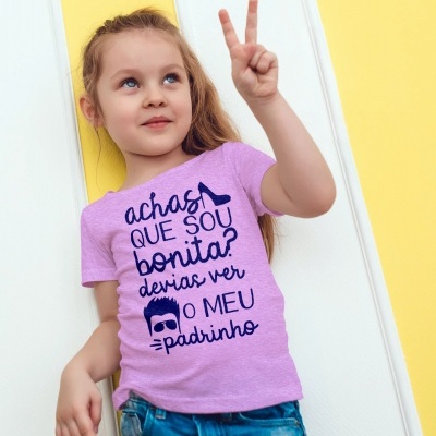 Menina com t-shirt lilás de menino. Texto azul escuro e fundo amarelo e branco.