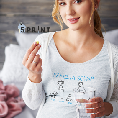 Mulher grávida com camisola familiar cinzenta clara segurando comprimido e copo de água