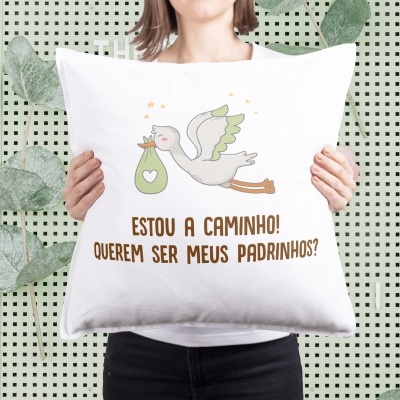 Almofada branca com ilustração de cegonha e texto em castanho em fundo decorativo