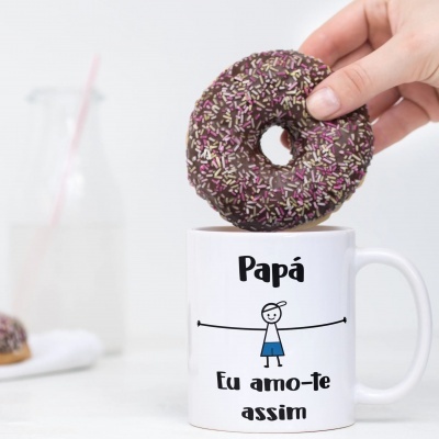 Caneca branca com texto e boneco segurando donut coberto de chocolate e granulados