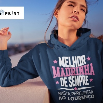 Mulher com camisola azul escuro com texto em branco e rosa ao ar livre ao pôr do sol