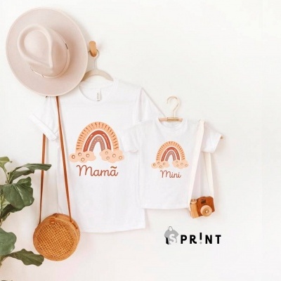 Duas t-shirts brancas com estampas de arco-íris e textos 