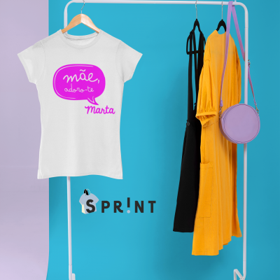 Expositor com t-shirt branca, vestidos negro e amarelo, mala lilás e vasos de plantas no chão