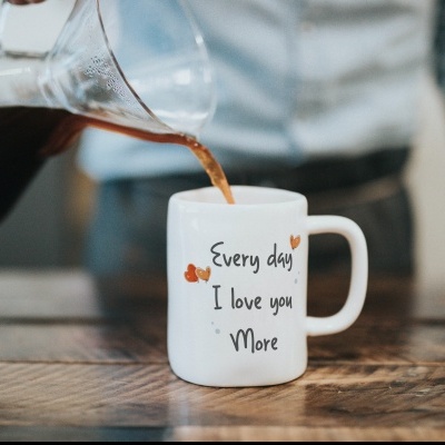 Caneca branca com texto e corações, café a ser servido nela