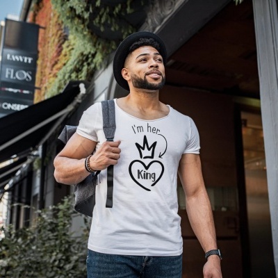 Homem com t-shirt branca estampada e mochila preta em cidade