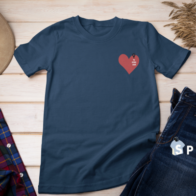 T-shirt azul escura com coração vermelho e texto, chapéu castanho, camisa xadrez e calças de ganga escuras