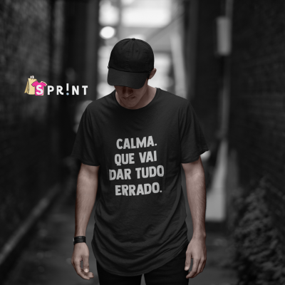 Homem com t-shirt preta e boné num beco entre paredes de tijolos