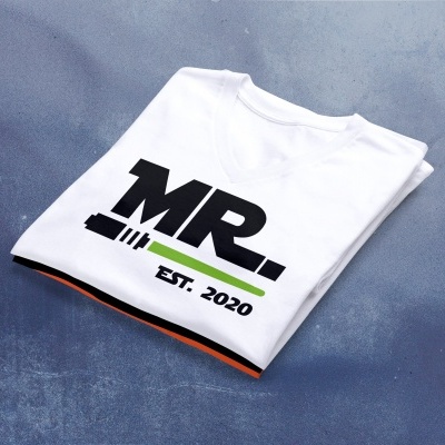 T-shirt branca com estampa MR.. EST. 2020 dobrada numa superfície cinzenta.