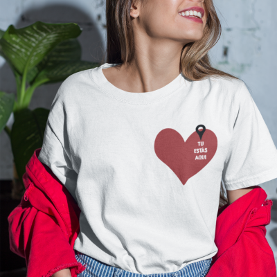 Camisola branca com coração vermelho e texto 'TU ESTÁS AQUI'