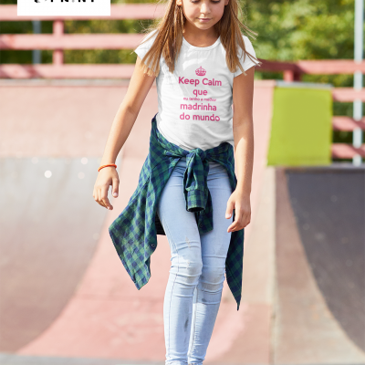 Menina com camiseta branca e texto colorido andando de skate em parque de skate