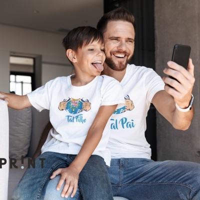 Homem e criança de t-shirts brancas fazendo selfie no sofá