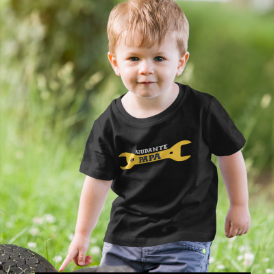 Camisola preta com estampado amarelo 'AJUDANTE DO PAPÁ' usada por criança num ambiente exterior verde